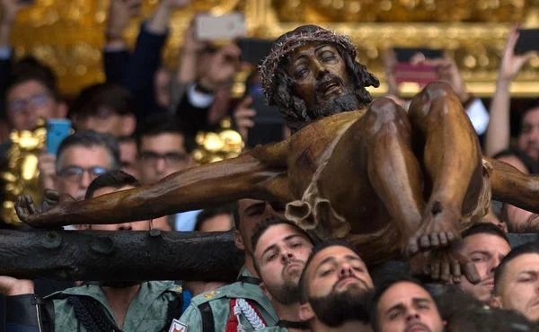 Membros da Legião Espanhola carregam uma estátua representando "El Cristo de la Buena Muerte" (o Cristo da boa morte) na Igreja de Santo Domingo de Guzman durante a procissão da semana Santa do 'Cristo de Mena' em Málaga, no sul da Espanha. Crédito: JORGE GUERRERO / AFP